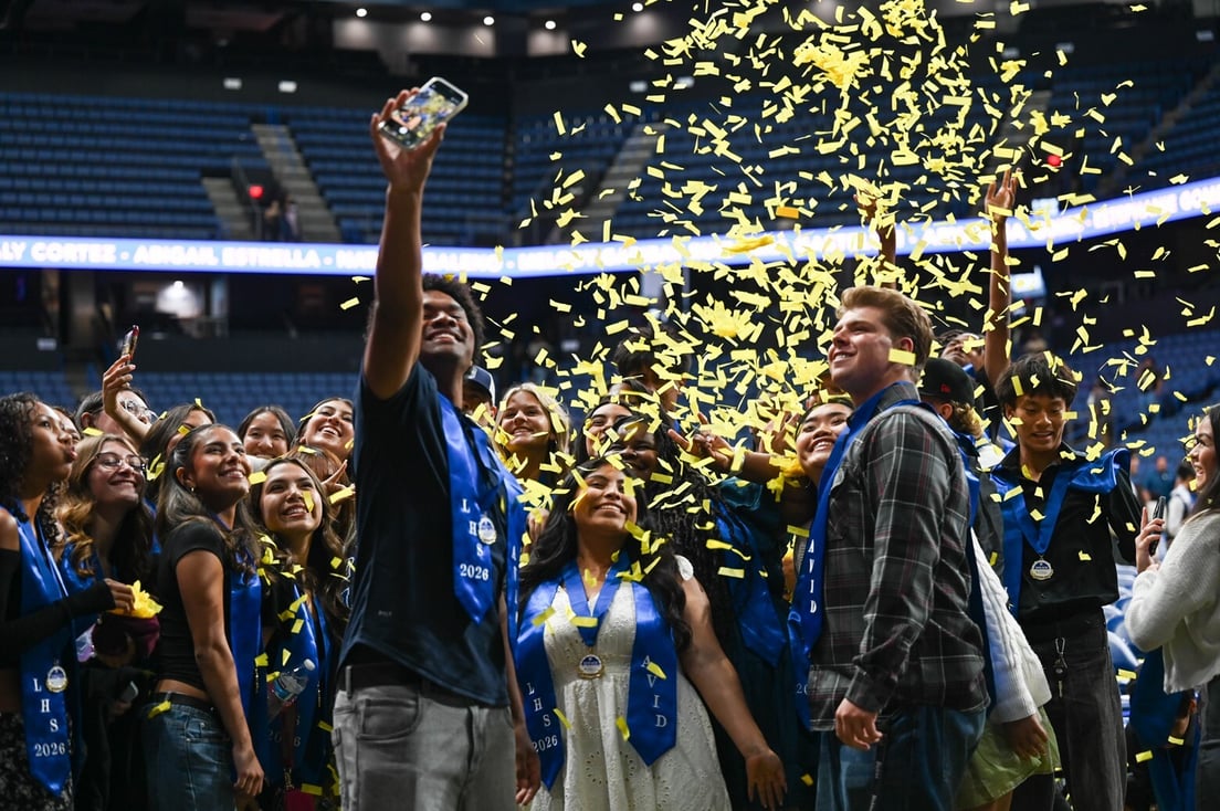 Graduating seniors celebrating and taking a selfie with confetti falling