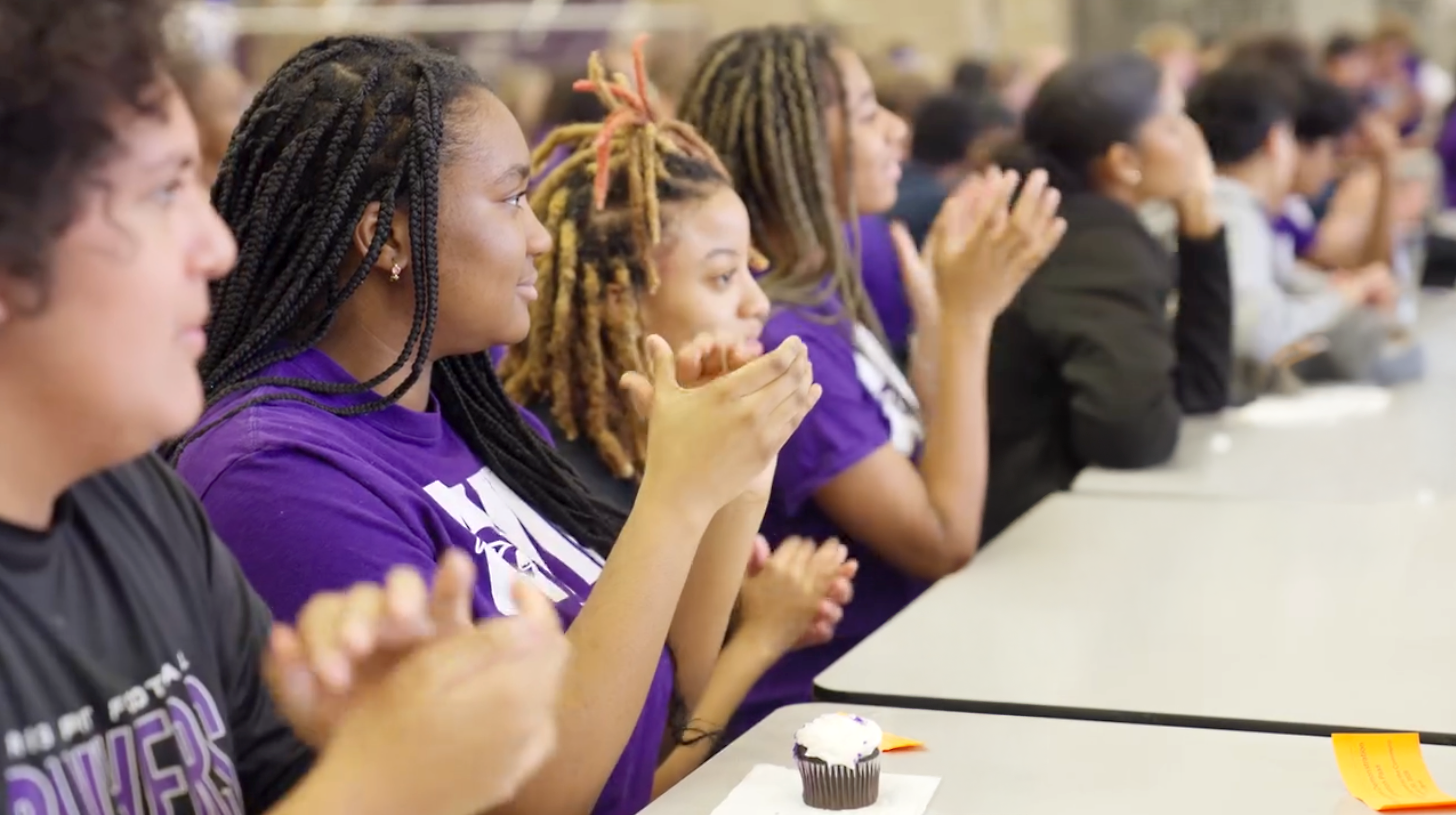 Seated students smile and clap